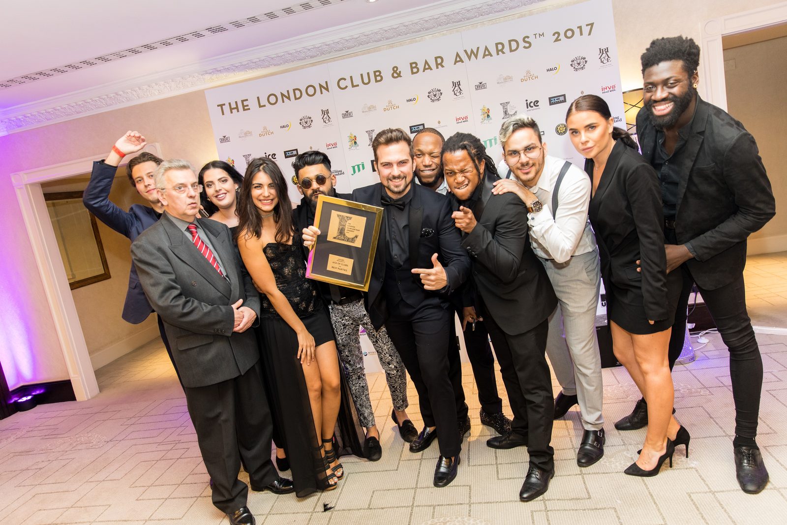 AOC team celebrating together on stage after winning an industry award, all smiles