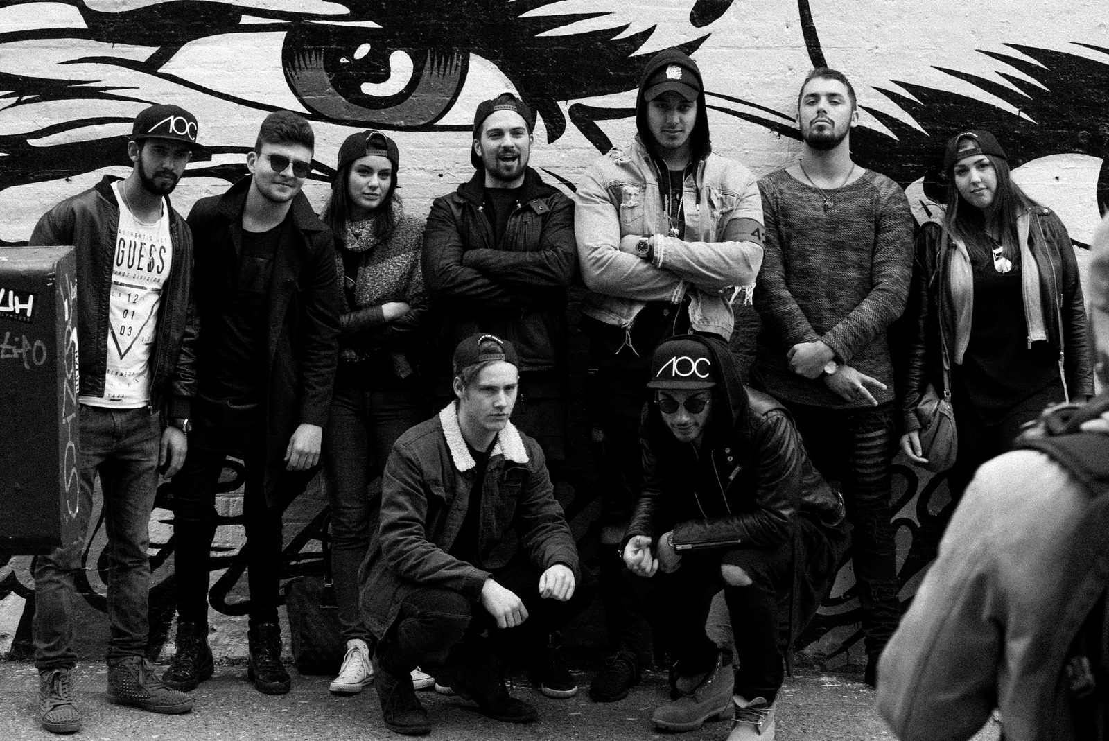 AOC crew group photo together in front of a Shoreditch graffiti mural