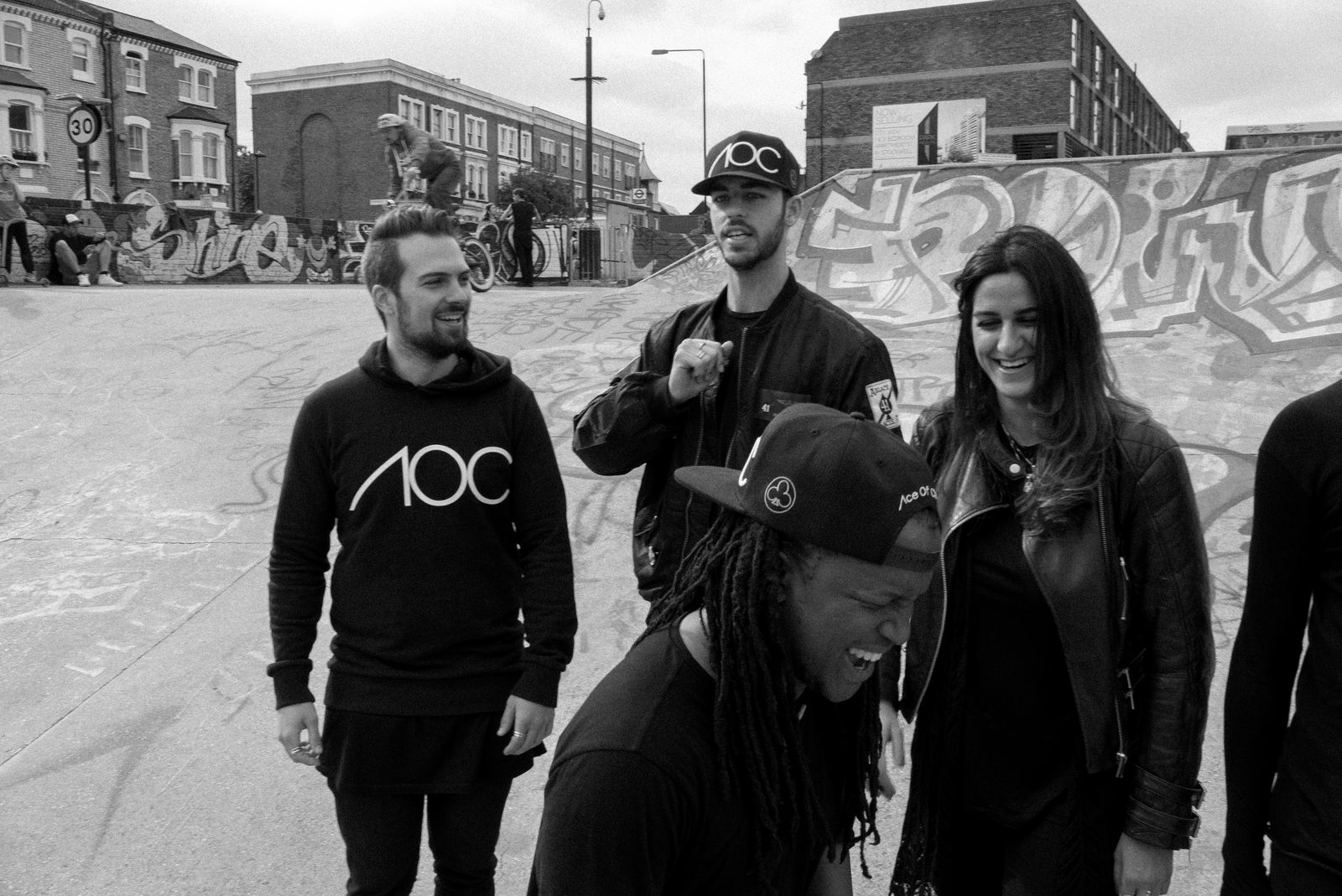 Small group of AOC crew laughing together outdoors in a Brixton park
