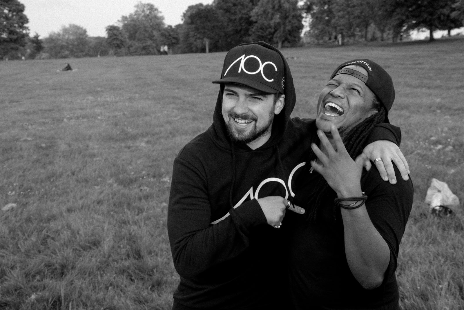 Two AOC crew members hugging and laughing together outdoors