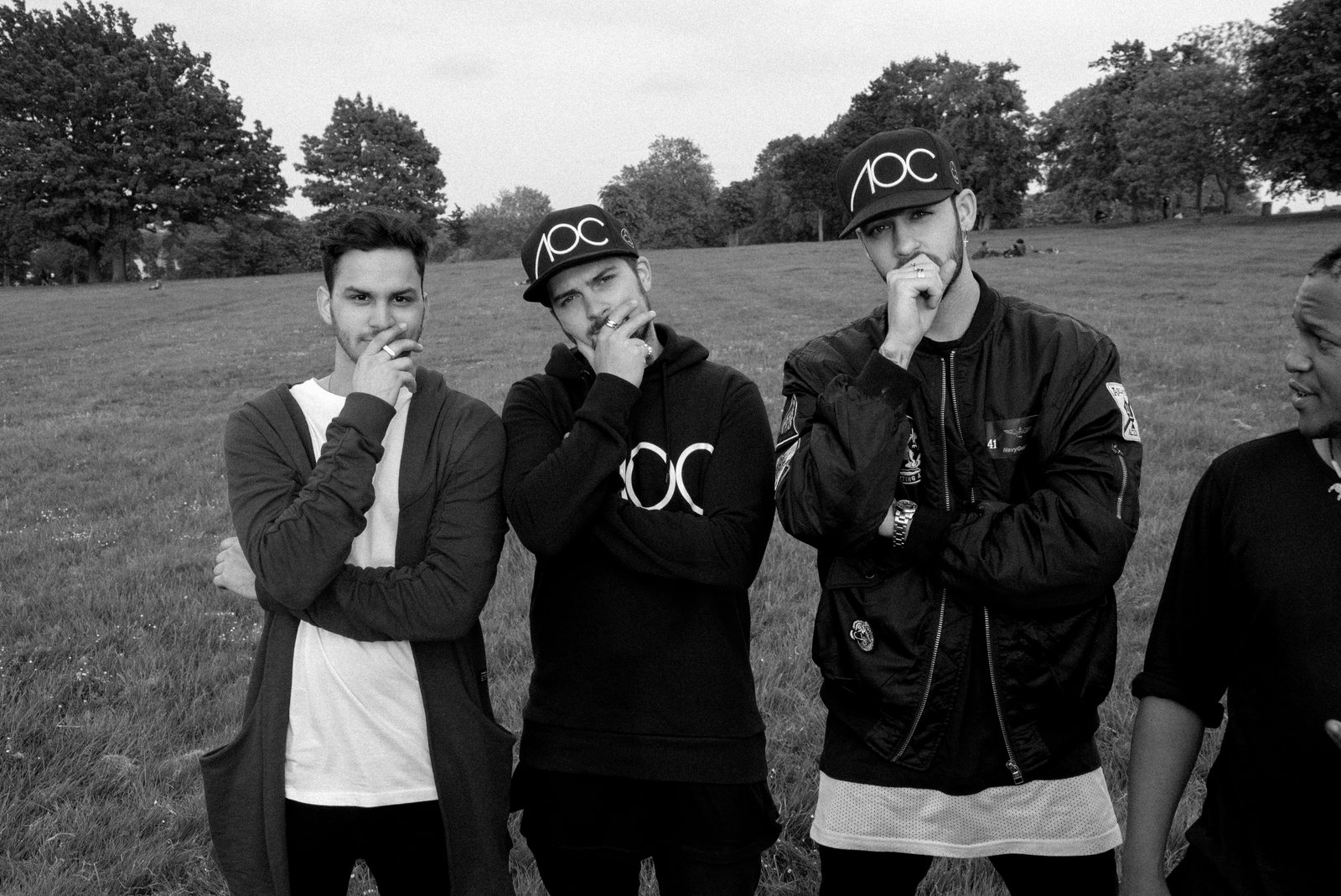 Three AOC crew members posed together outdoors, laughing