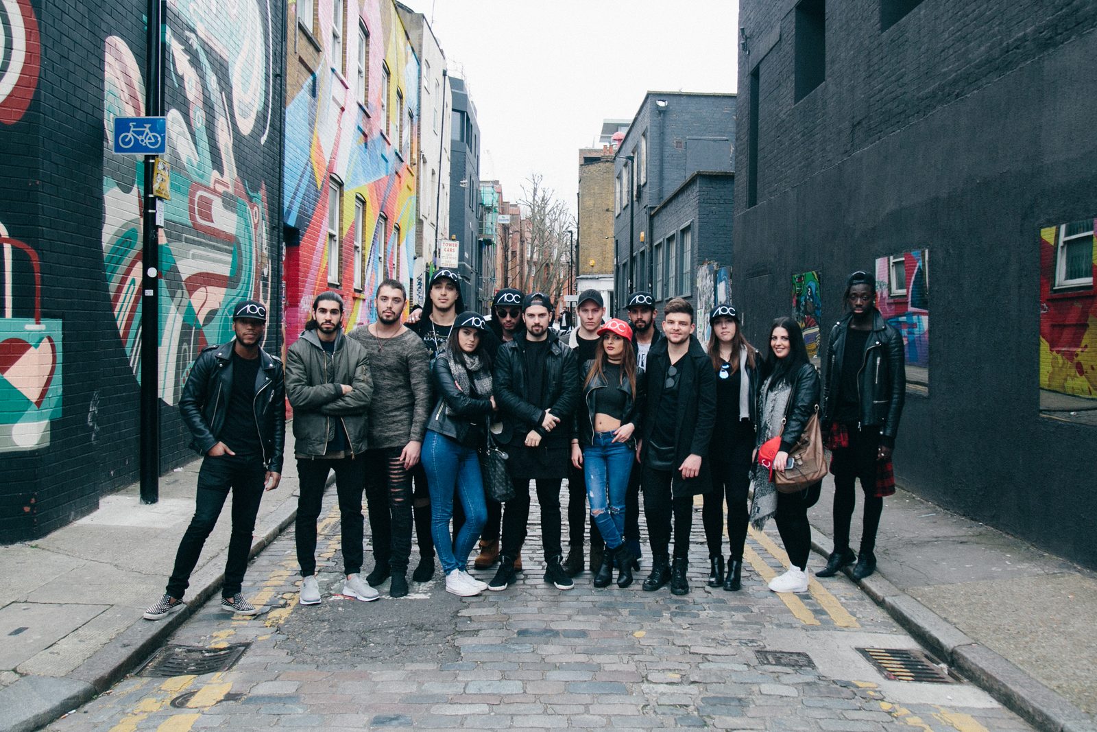 Large AOC crew group shot filling a graffiti-lined Shoreditch alley